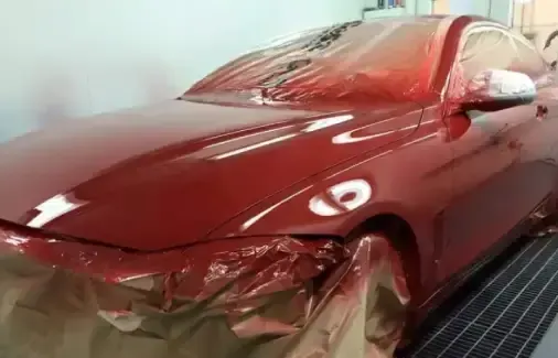 Coche rojo en la cabina de pintura USI